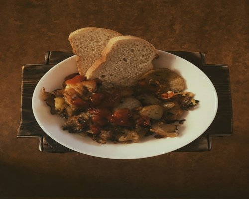 A warm bowl of soup with vegetables and rustic bread