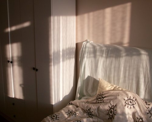 A warm bed with soft pillows in a calm room